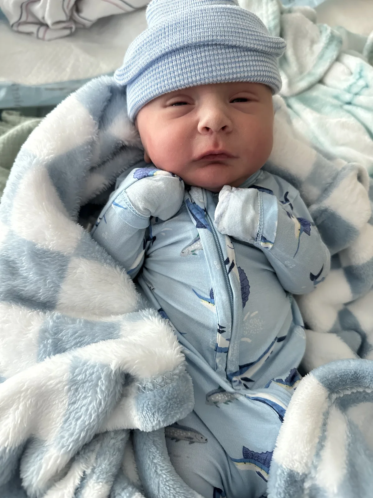 Your newborn son wrapped in a blue cap and blanket on October 30, 2025